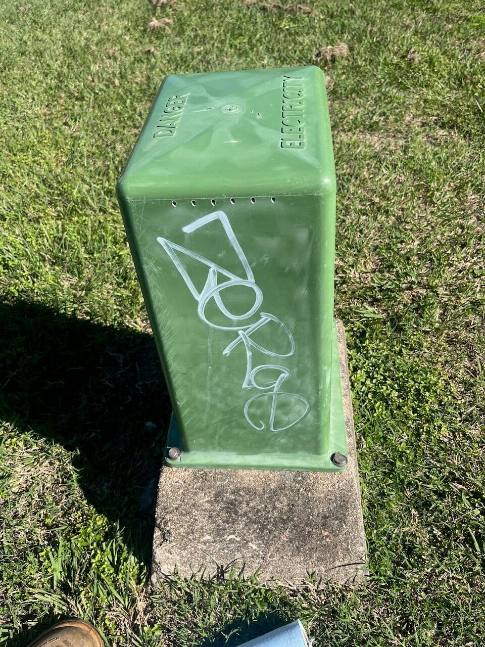 Green electrical box with graffiti before removal