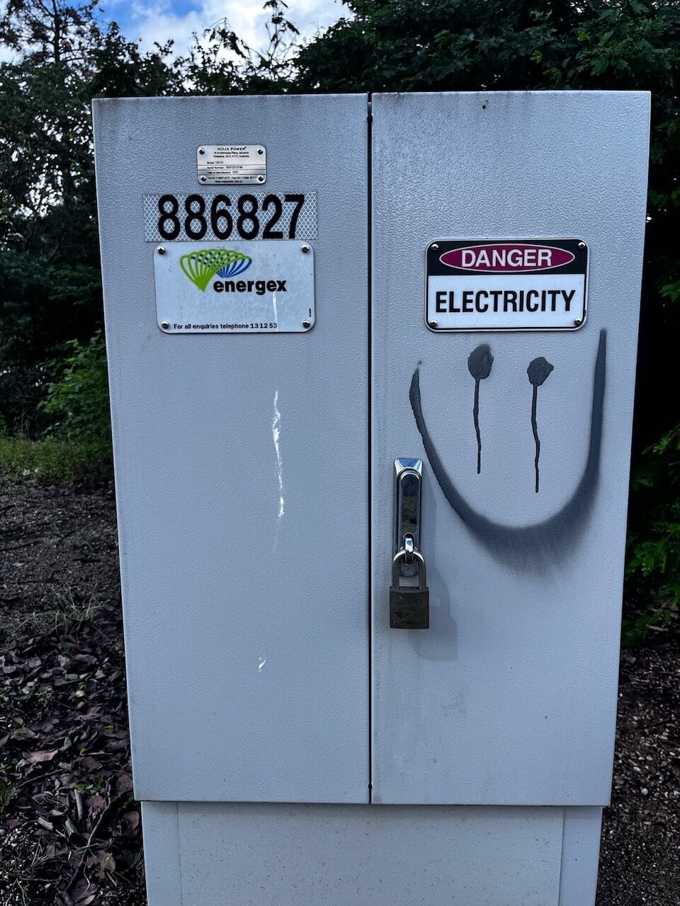 Green electrical box with graffiti before removal